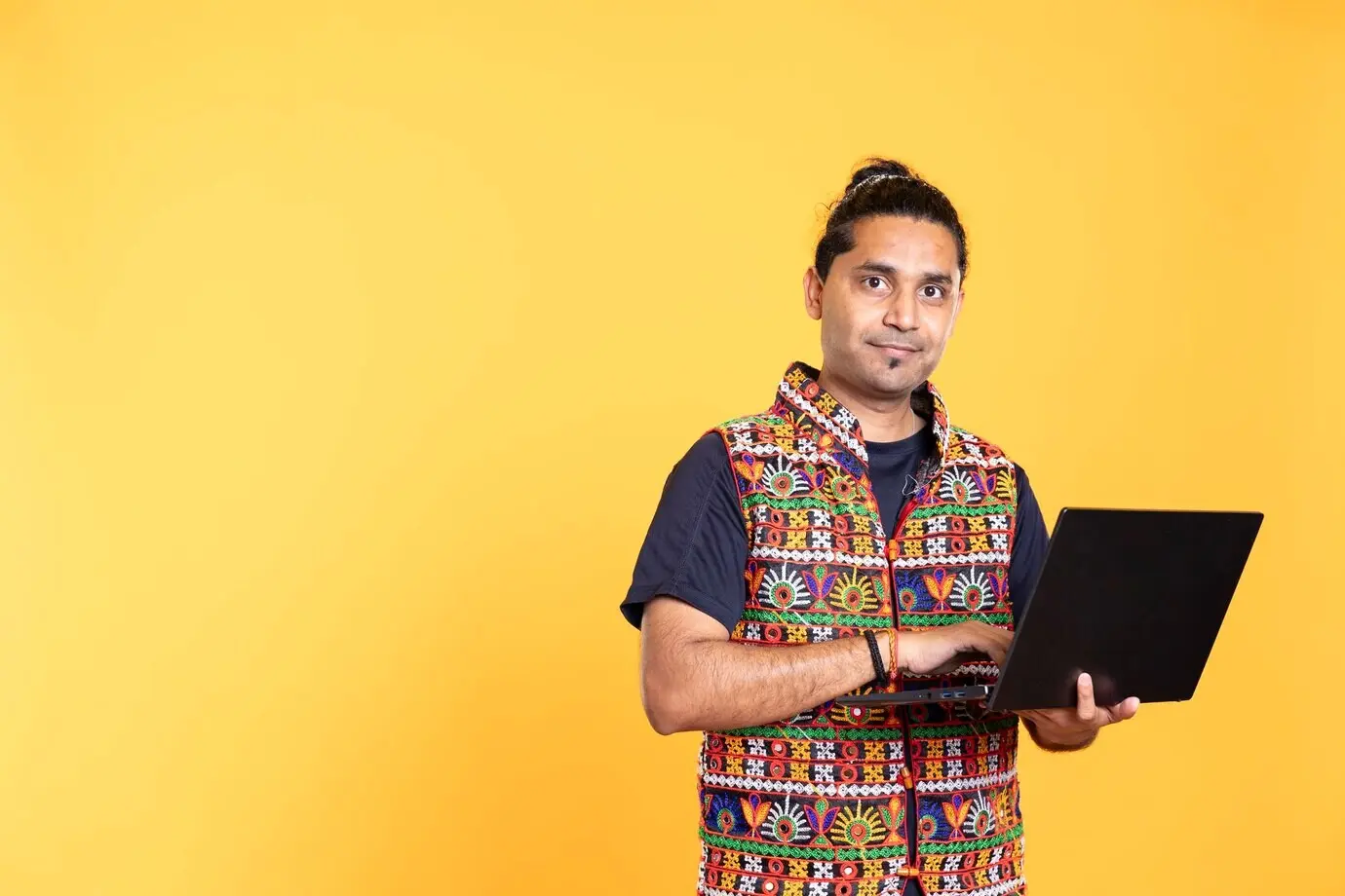Portrait d’un homme souriant utilisant un ordinateur portable pour réaliser des tâches liées aux affaires.