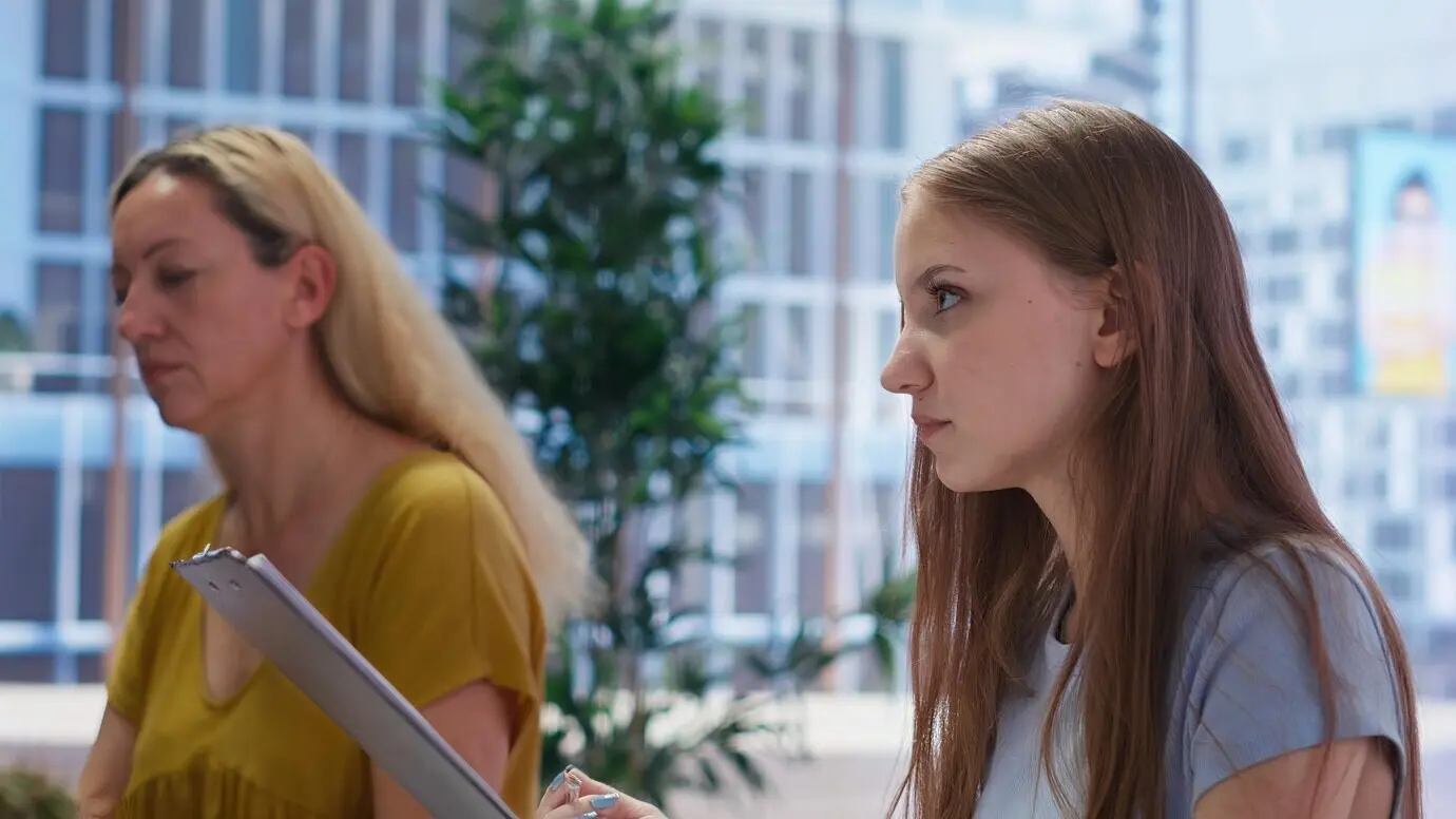 Jeune adulte lisant un plan financier personnalisé remis par un conseiller financier.